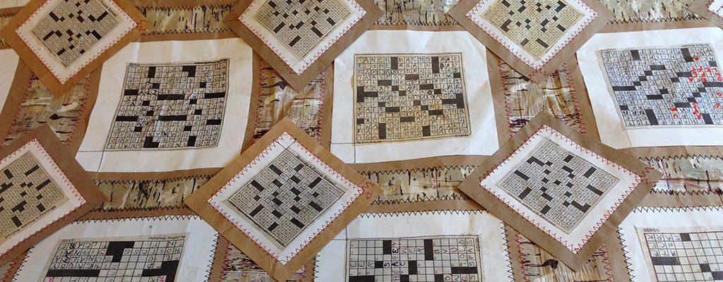 Quilt made of crossword puzzles in black, white, brown, and beige