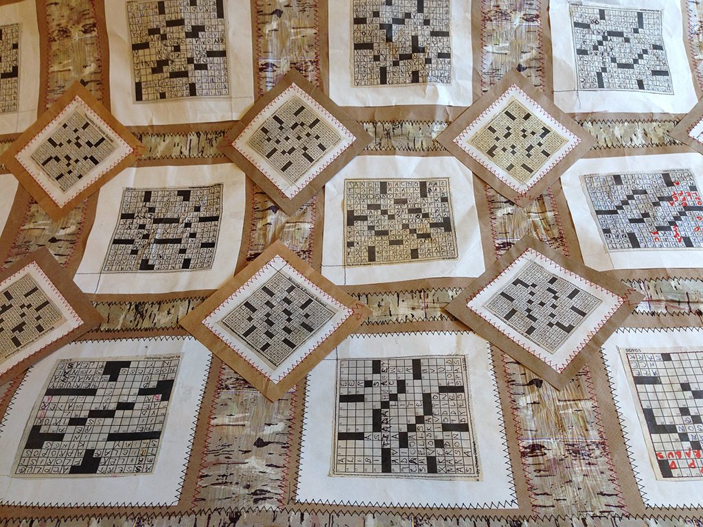 Quilt made of crossword puzzles in black, white, brown, and beige